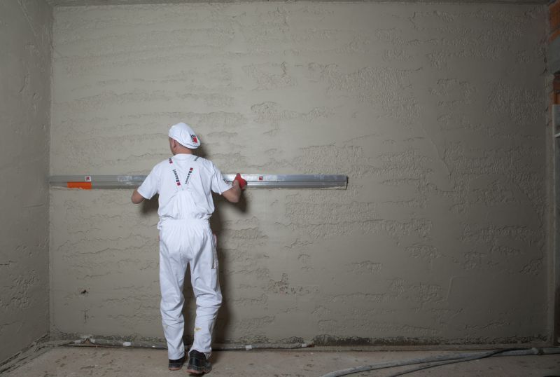 Ściąganie tynku łatą po narzuceniu na ścianę