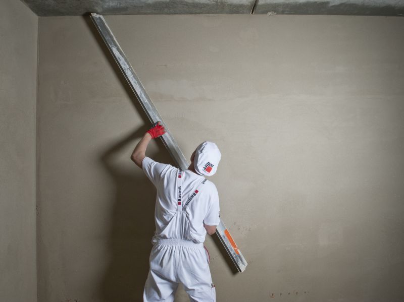 Wyrównywanie wstępnie związanego tynku poprzez drapanie powierzchni łatą trapezową