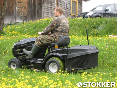 Wiosną koszenie bujnej trawy z traktorkiem kosiarką