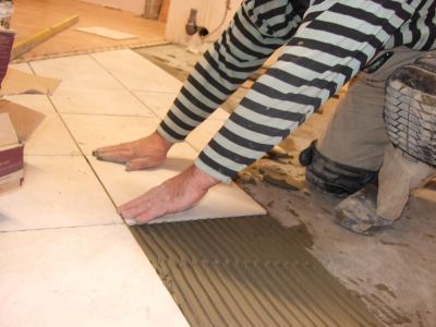 Kładzie się płytki ceramiczne (bądź inną wykładzinę podłogową
