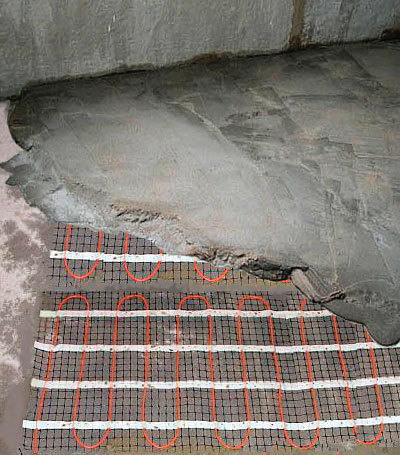 Matę grzejną pokrywa się warstwą zaprawy (do 5 cm grubości). Nie jest jednak ona konieczna